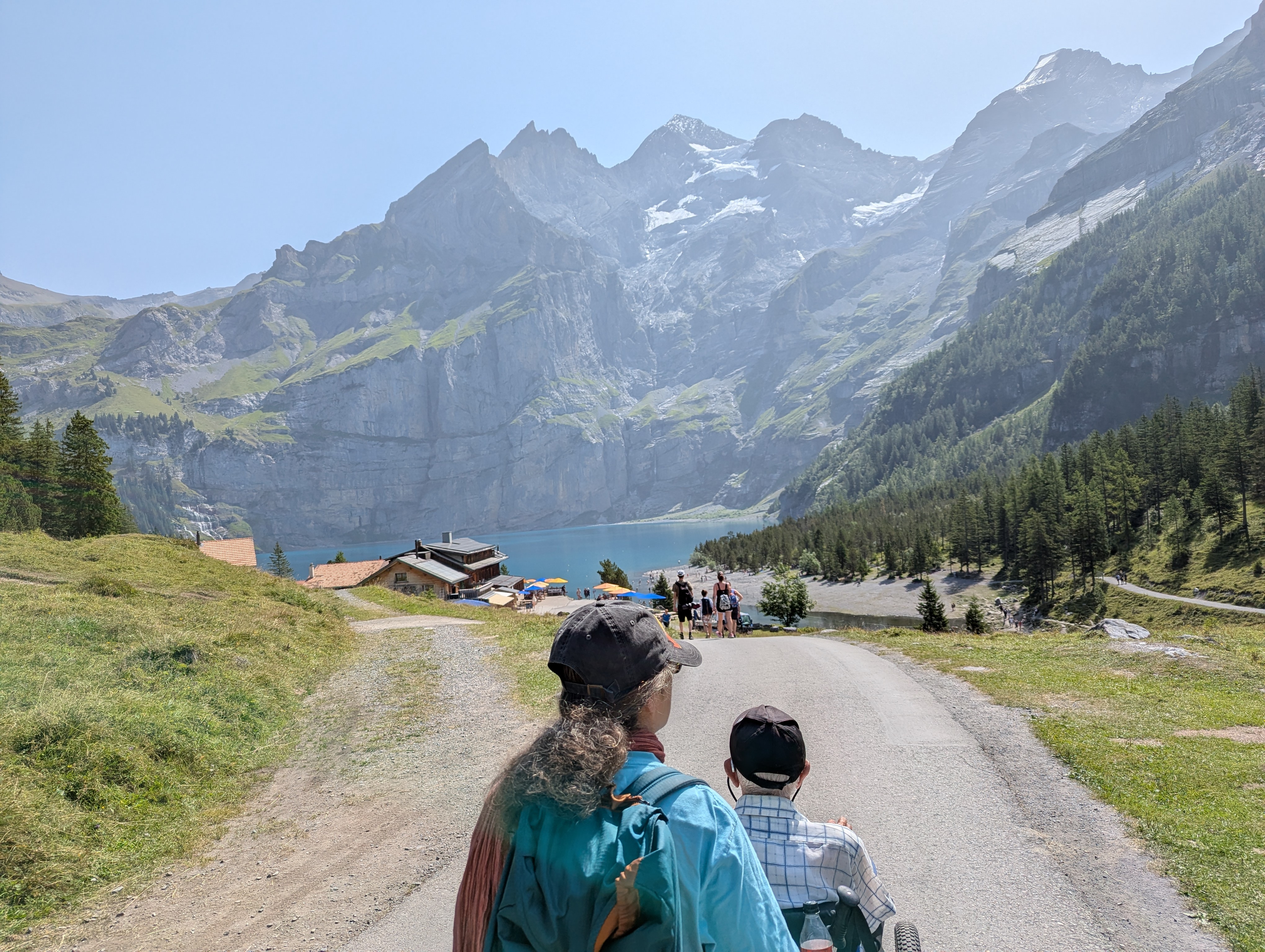 view of mountains and lake in Switzerland. Man sat in ePush all terrain wheelchair being pushed by women